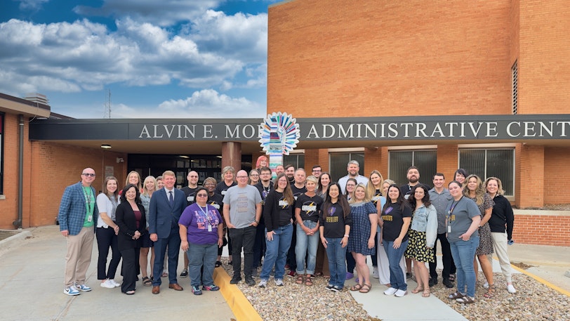 Group photo of Wichita Public Schools team members standing outside the school.